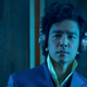 John Cho listens to some jams on headphones as Spike Spiegel in his classic suit in Netflix's live-action Cowboy Bebop.